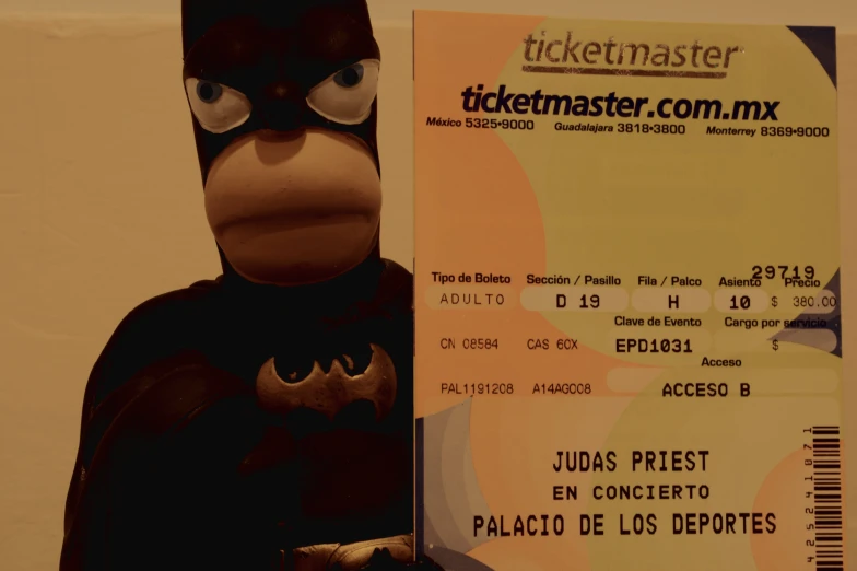 a ticket shaped like a batman is next to the toy