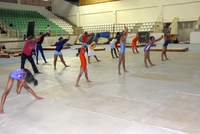 a group of people doing tricks in an indoor gym