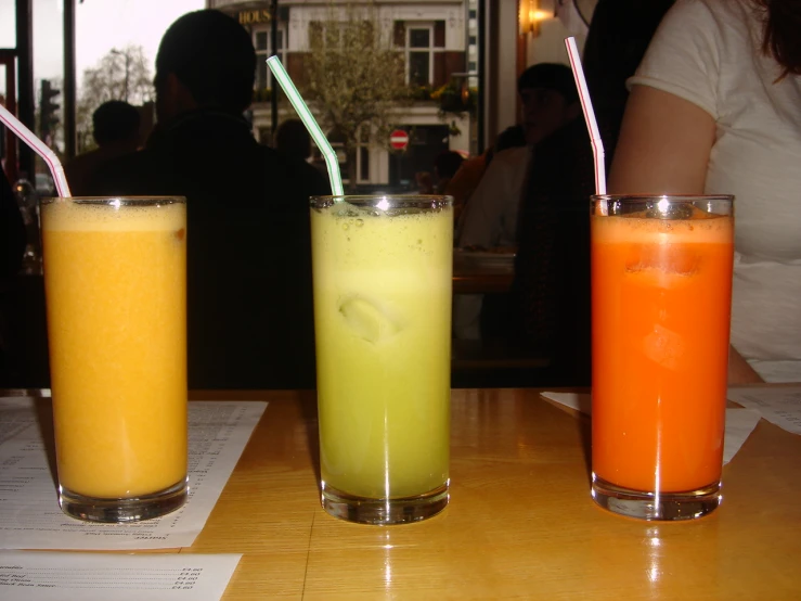 three different kinds of juices and drink on a table