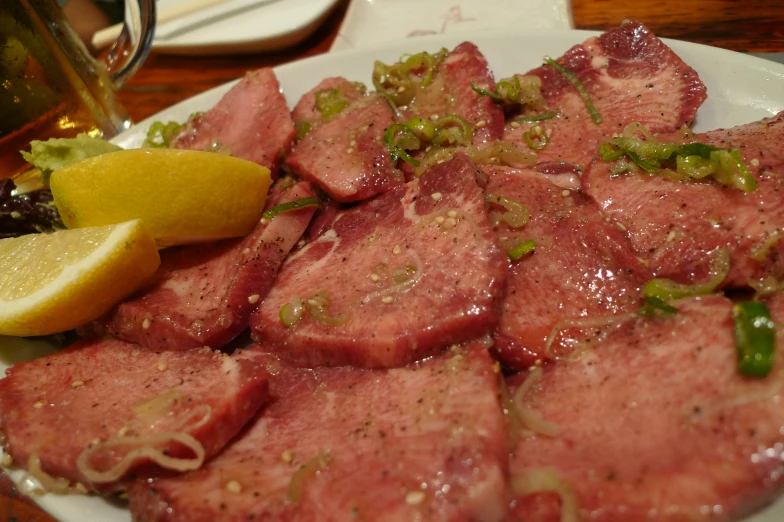 closeup of a plate with sliced meat and salad on the side