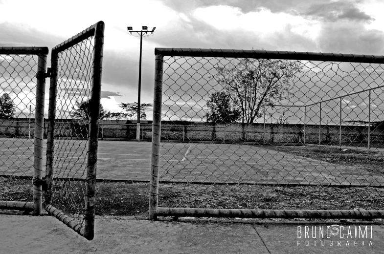 two gates, one closed to the sky, are in an empty field