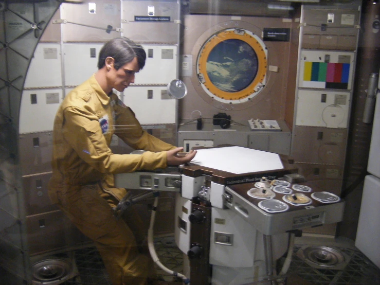 a man in a yellow uniform is doing soing on an oven