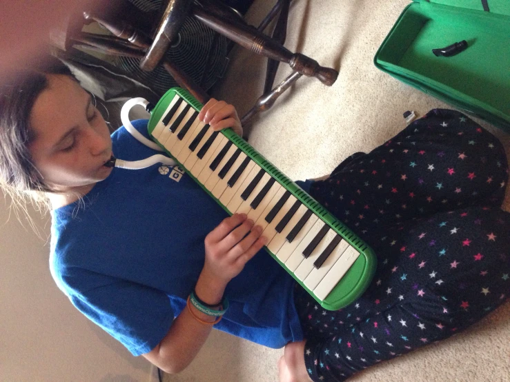 a little girl is sitting down playing the piano