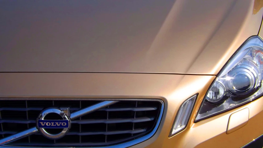 the front end of a gold colored volvo