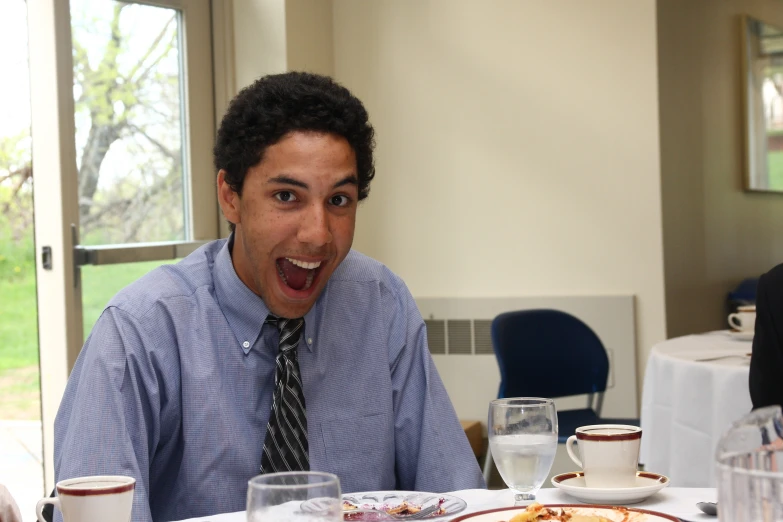 the young man is laughing and excited for his food