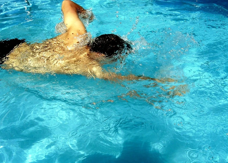 a person is swimming in a blue pool