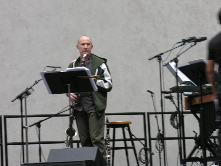 a man with an instrument is in front of microphones