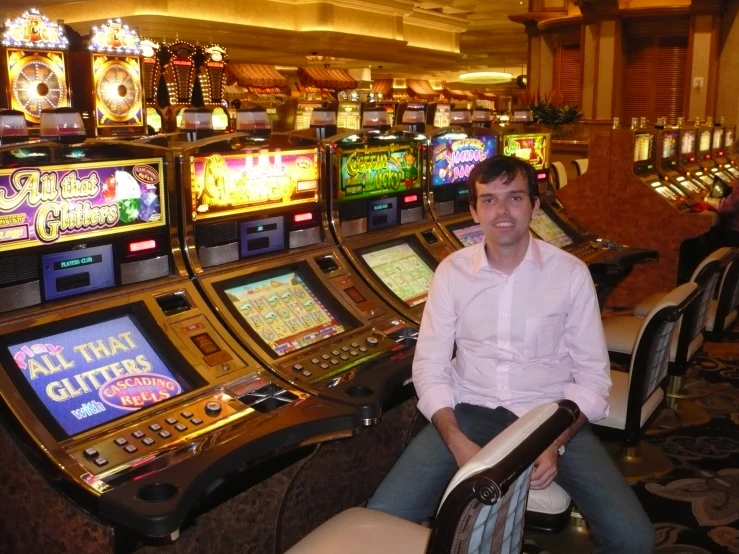 a man sitting at the casino in front of slot machines