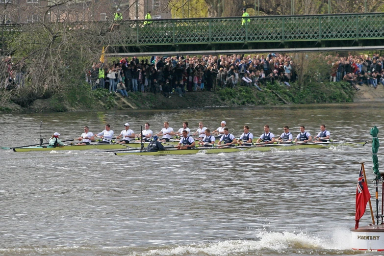 a long boat is in the water being rowed by a row boat