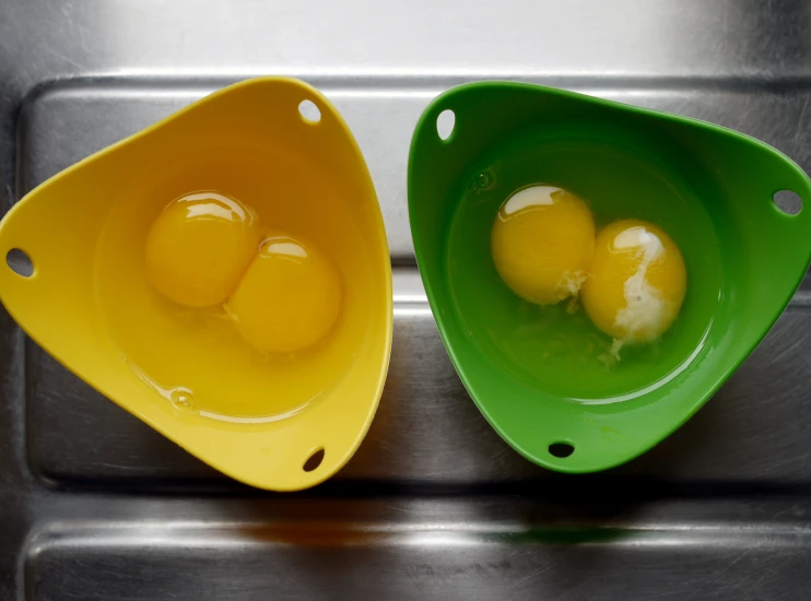 two separate bowls filled with eggs on top of a table