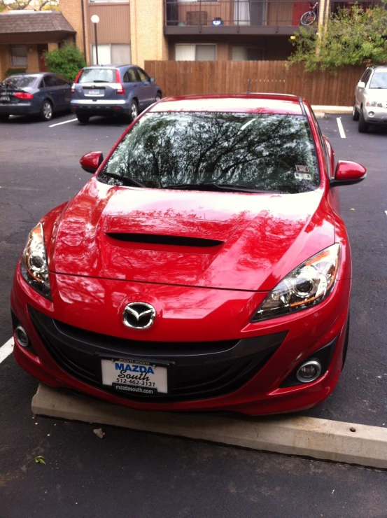 a bright red mazda parked in a parking lot