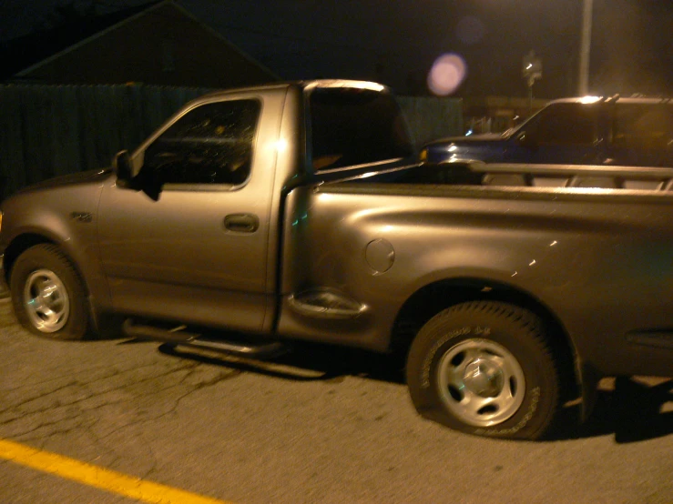 silver truck parked in parking lot on the side of the road