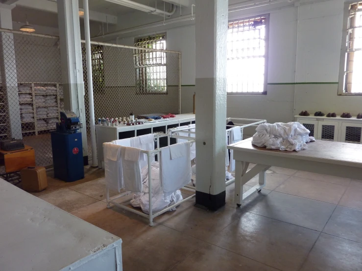 a warehouse with tables, hanging wall panels and paper on the ground