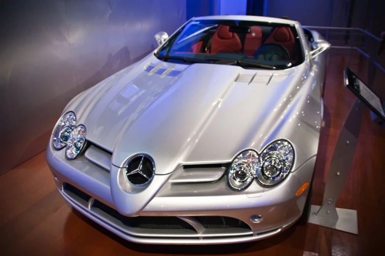 a silver mercedes roadster convertible parked inside of a building