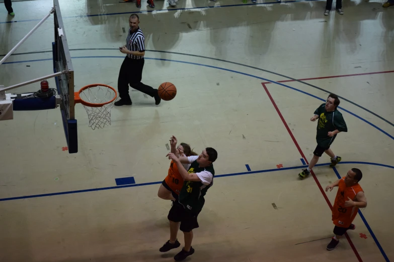 a bunch of people in a gym playing basketball