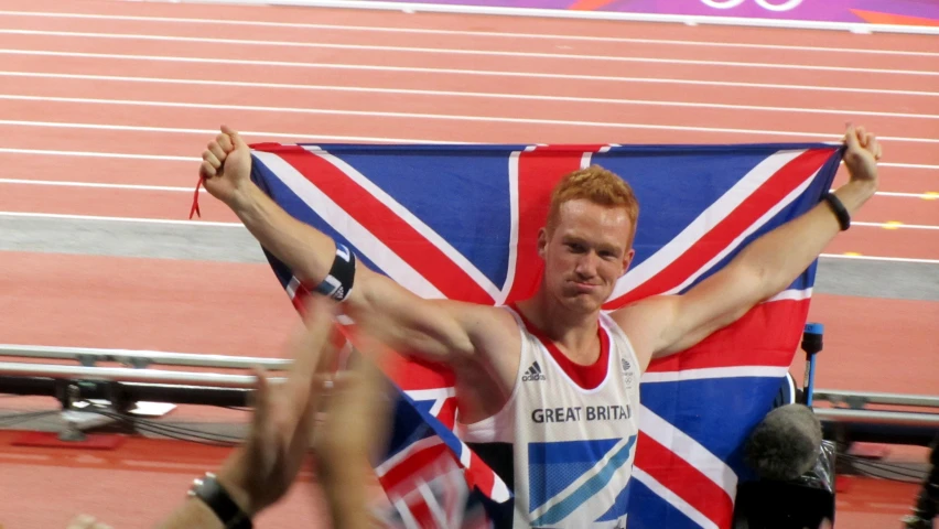 a man holding the british flag while cheering