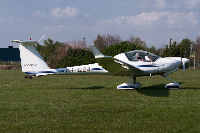 a small white airplane is parked on some grass