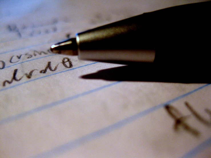 a close up of a pen on top of an open notebook