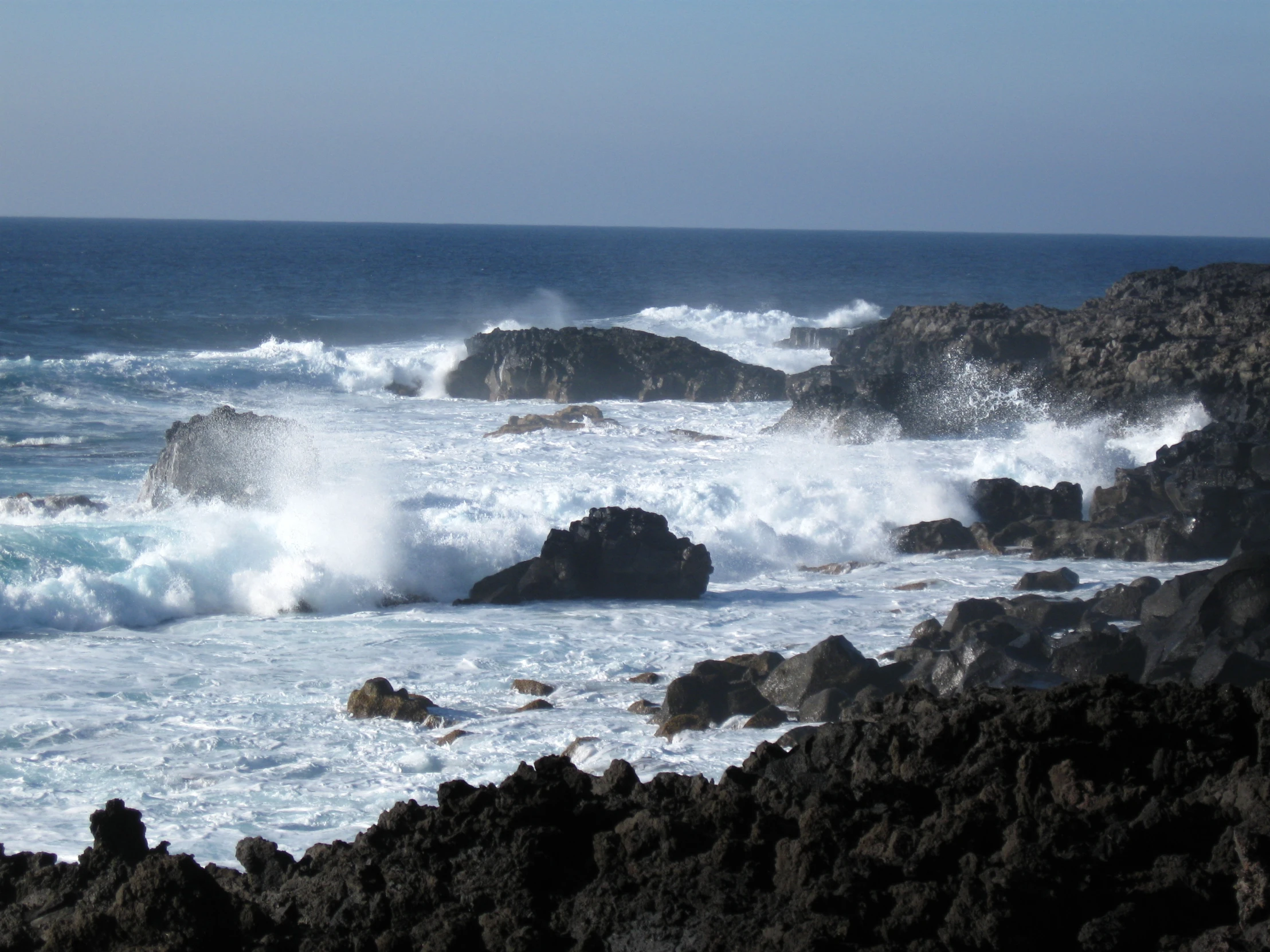 the rocky shore is full of waves crashing to shore