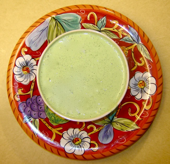 a colorful plate with a cup on top
