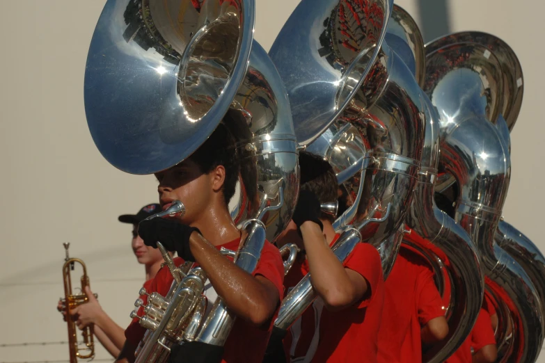 two boys are in red shirts playing the instruments