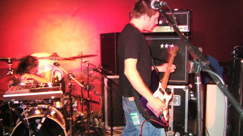 a guy playing his guitar in a music band