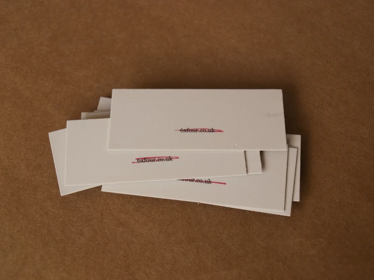 a pile of white envelopes with red ribbon