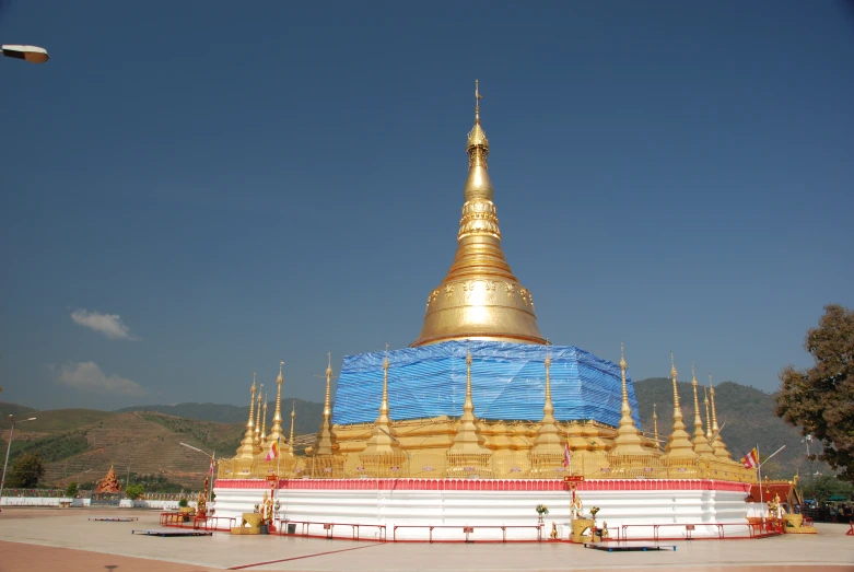 a very tall golden steeple sitting on top of a field