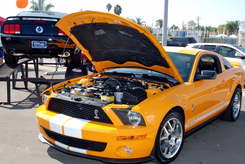 a yellow mustang is parked in a parking lot