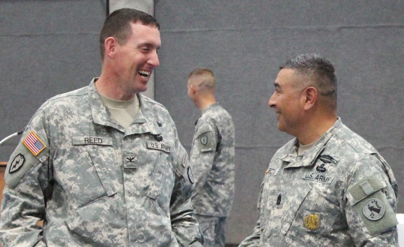 two men in uniform shaking hands at the same time