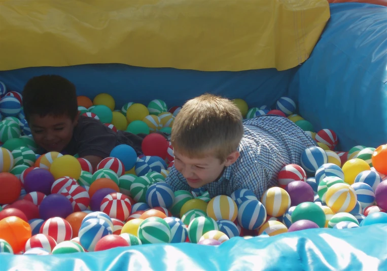 two children play in an inflatable pool of balls