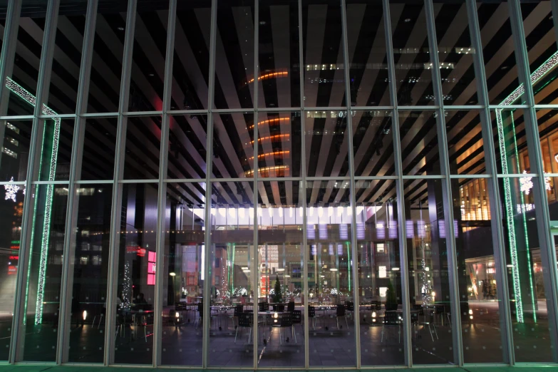 a glass window in a building with lights and a cityscape in the background