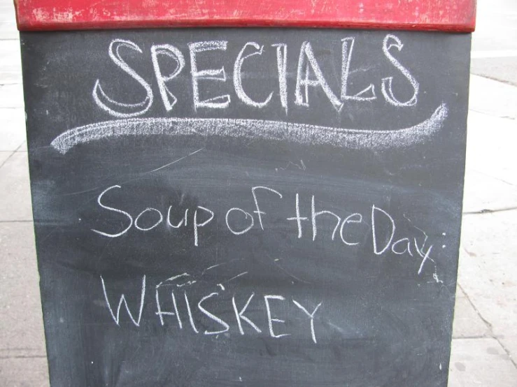 this chalkboard sign reads specials, soup of the day, and whiskey