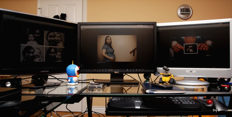 three computer monitors displaying black and white pos