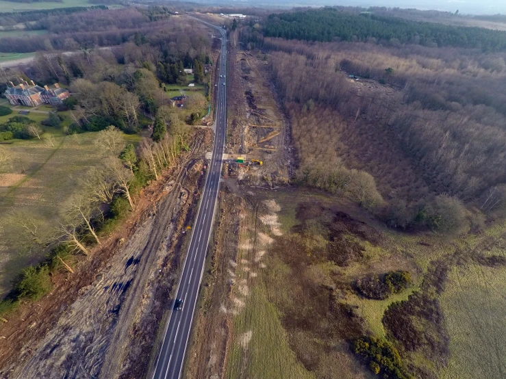 an aerial view of a country road surrounded by trees and brush