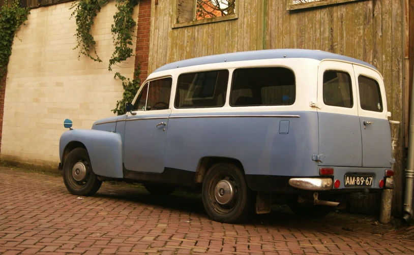 an old blue and white bus parked in front of a building