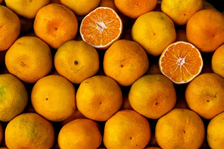 two peeled oranges in a large pile