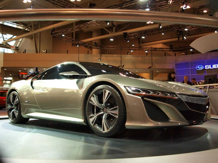 a silver car is on display at an auto show