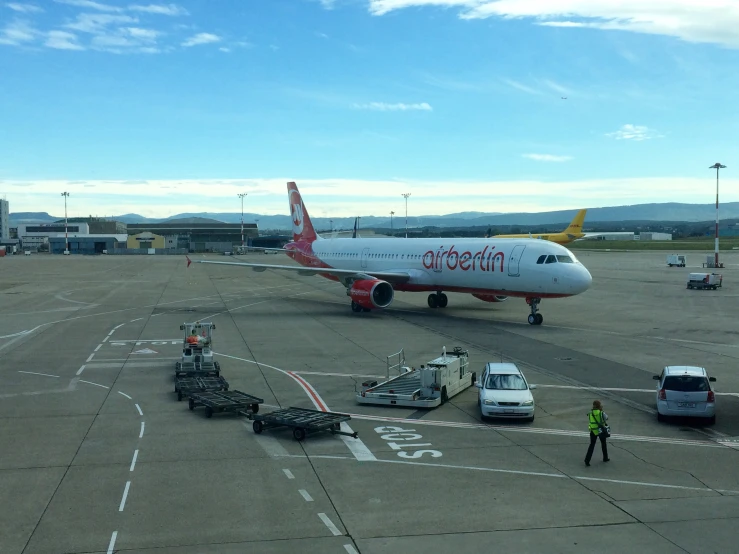 an airplane at the airport with some trucks nearby