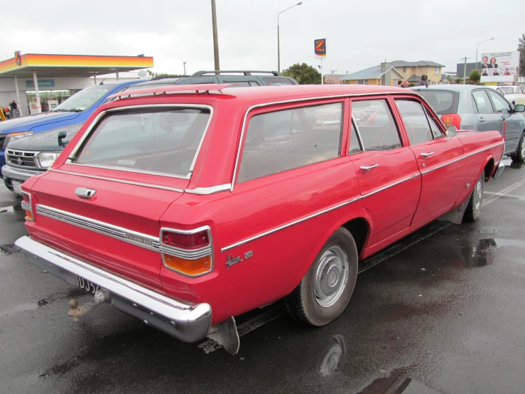the old fashioned station wagon is parked in the parking lot