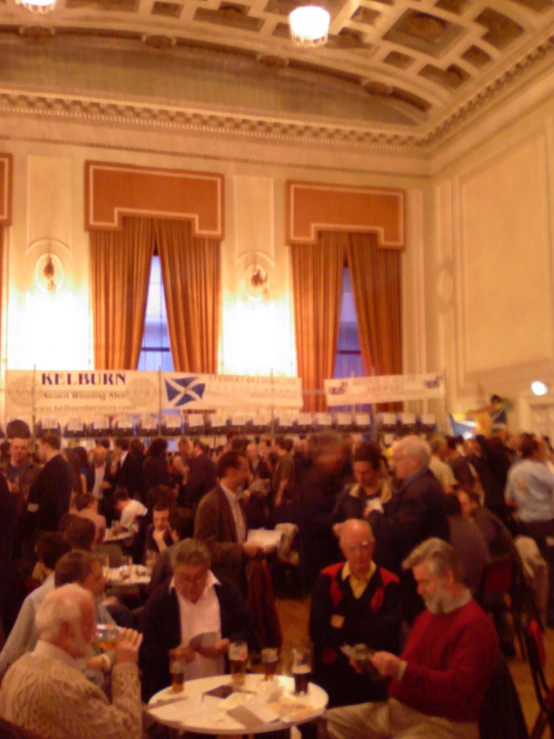 a room filled with tables with people eating and drinking