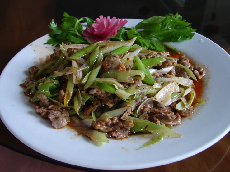 a white plate with meat and vegetable sitting on a table