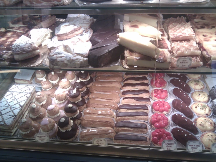 large assortment of cookies and deserts behind glass