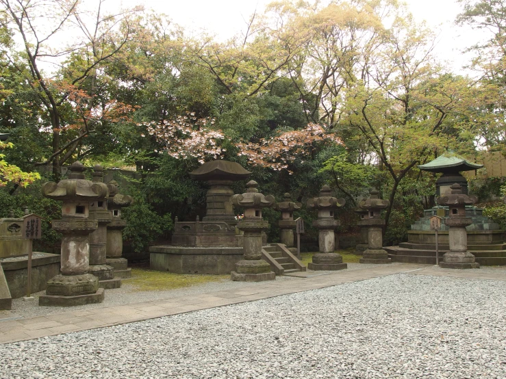 oriental style stone lanterns sit in a park area