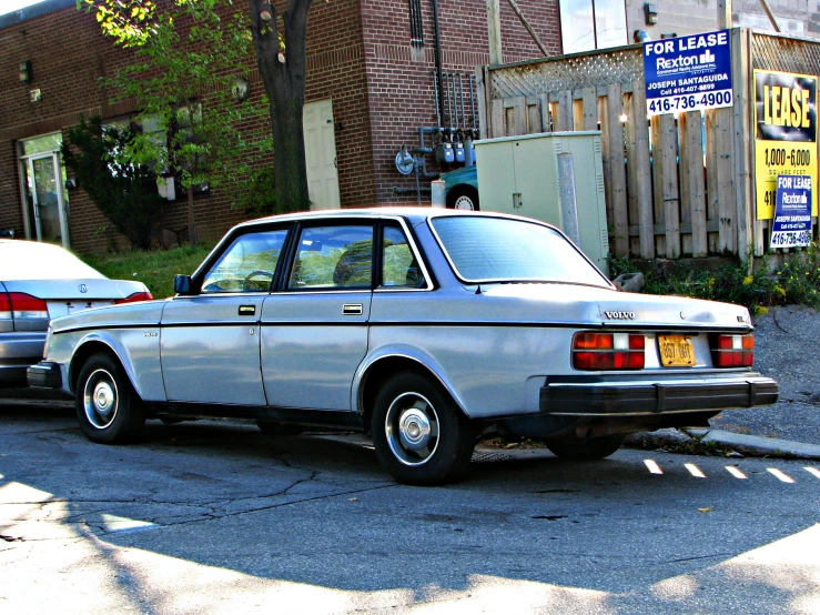 there is a silver car parked in front of a building