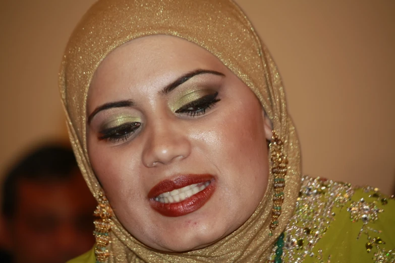 a woman wearing a head scarf looking in the mirror