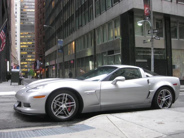 the sports car is on the road near the tall buildings