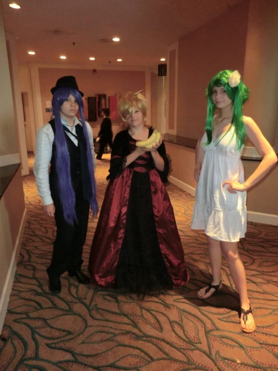 three women wearing formal dress in hallway