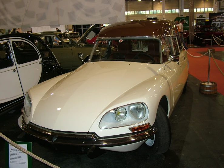 several classic automobiles are on display together at an exhibition