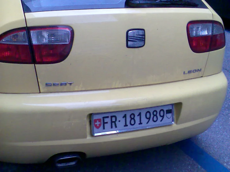 a bright yellow sedan sits in the parking lot